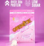 Grenade Protein Strawberries & Cream whey protein pouch with 30g protein displayed on a pink background with a scoop of protein powder.